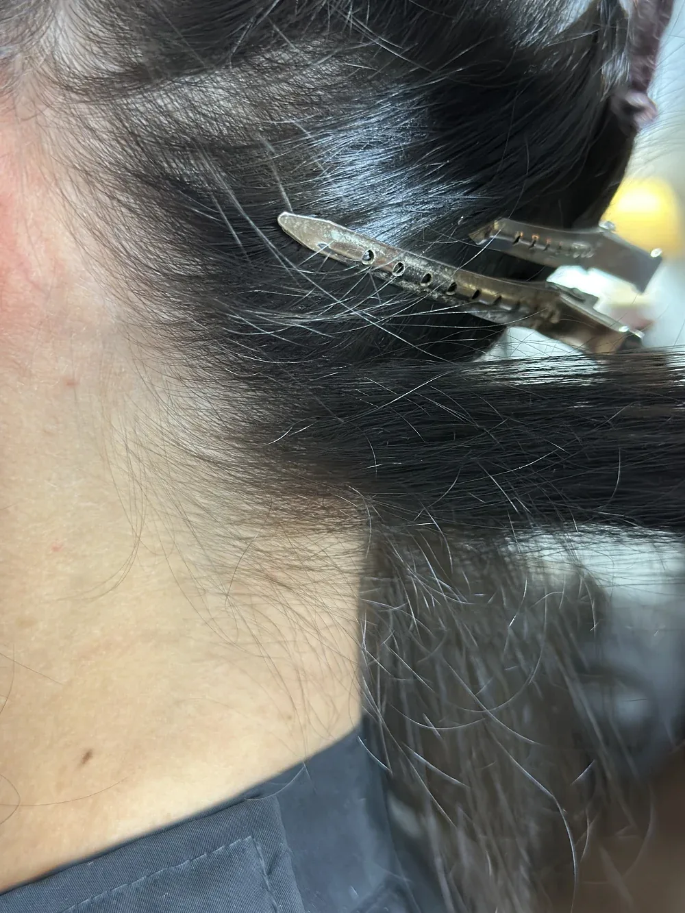Détail d’un point de micro-kératine façonné à la main sur une mèche brune
