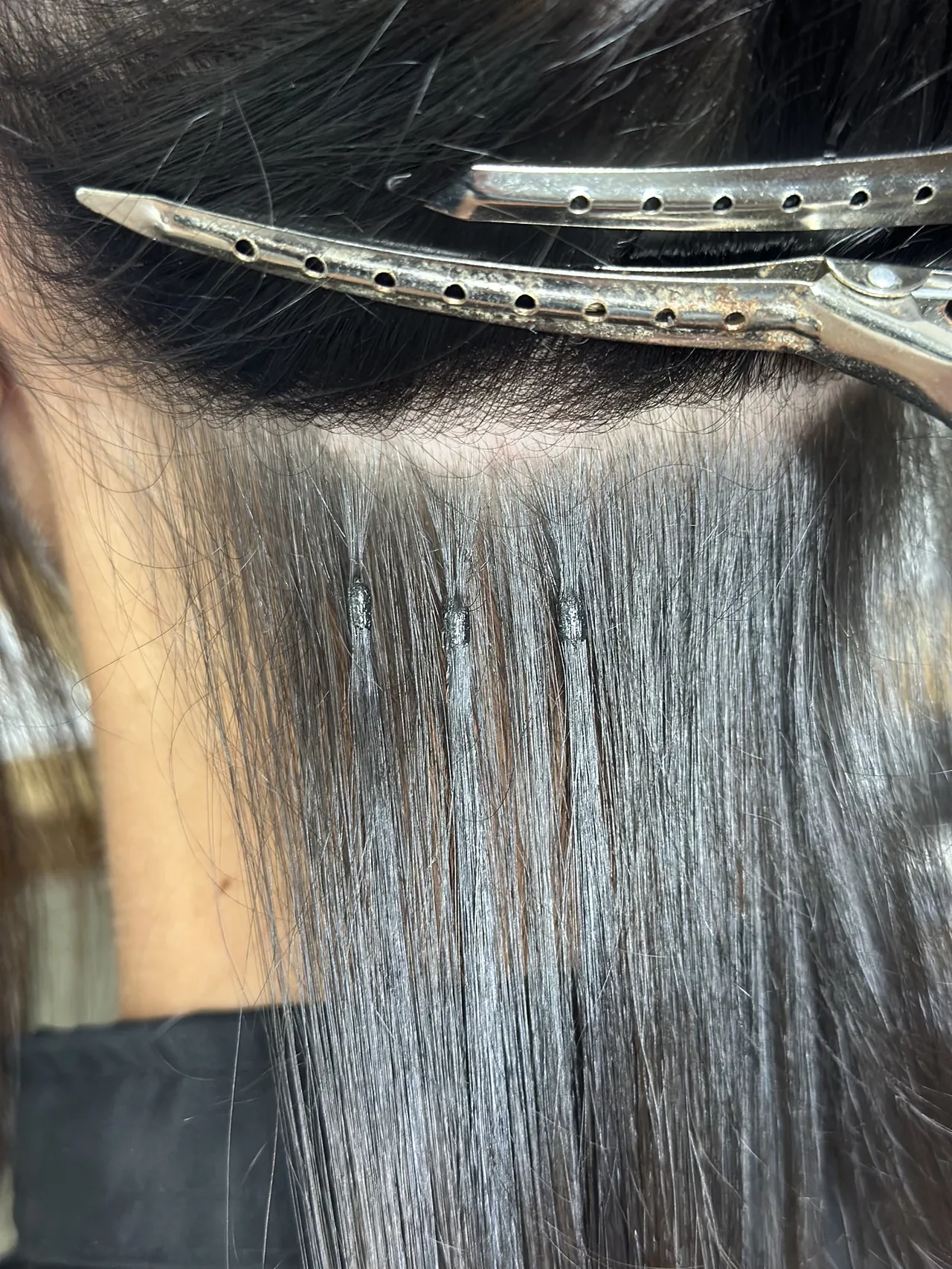 Fixation d’une extension à la kératine près des racines sur cheveux bruns